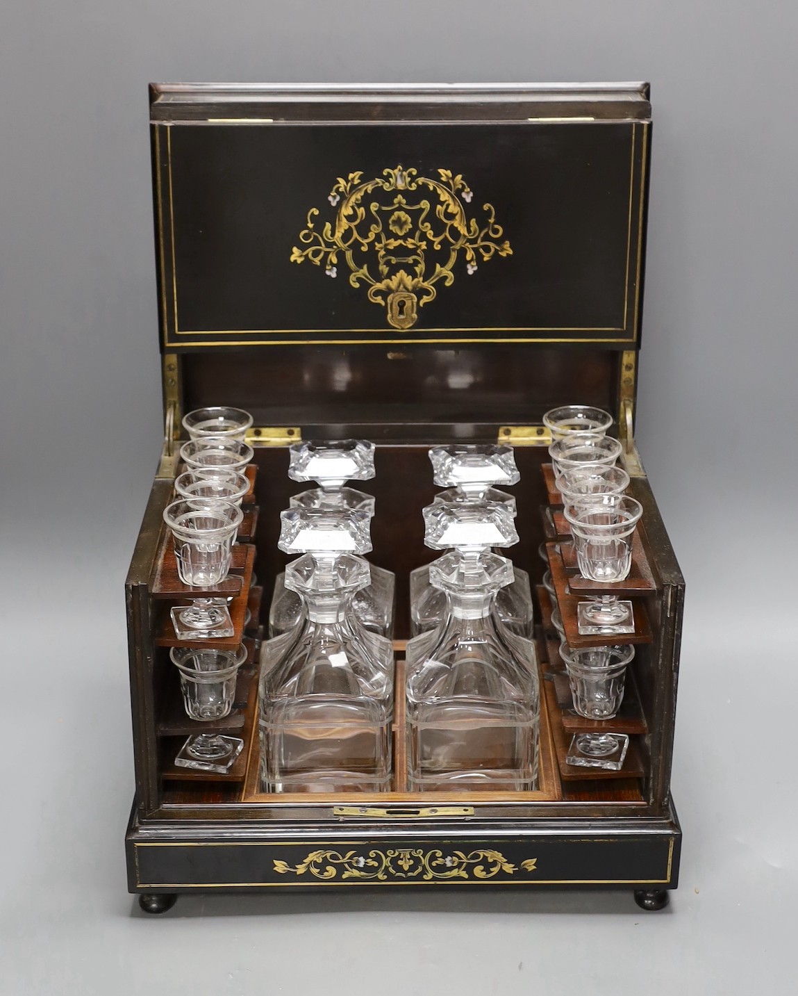 A 19th century mother of pearl and cut brass inlaid liqueur casket, 32cm, containing four original glass decanters and stoppers and 16 liqueur glasses